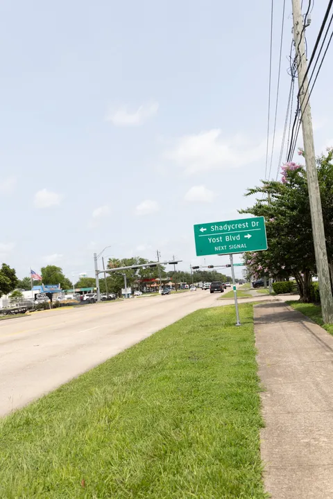 Green road sign on Broadway pointing toward Shadycrest Drive and Yost Boulevard at the next traffic signal.