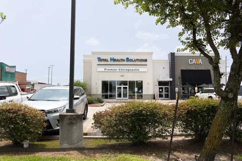 Premier Chiropractic Town Center storefront beside CAVA, with the parking area in front.