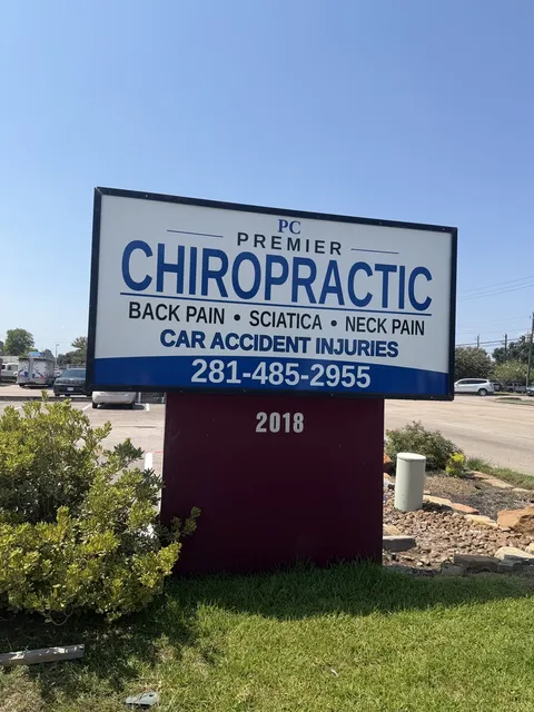 Blue Premier Chiropractic roadside sign with the 2018 address marker at the Old Town Pearland location.