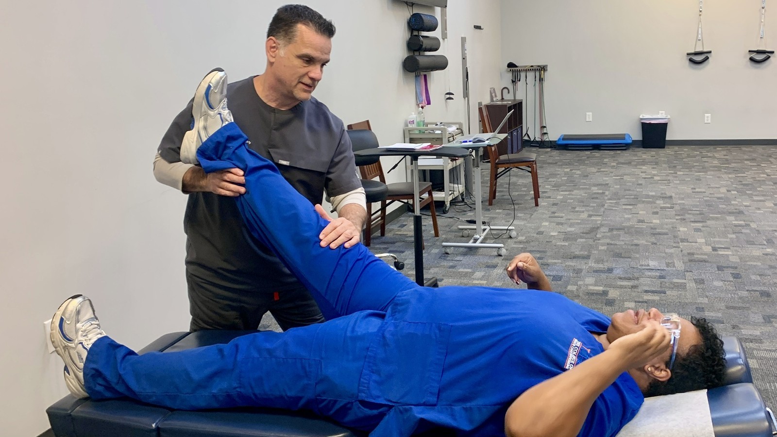 Chiropractor examining a patient's lower back and leg for sciatica at Premier Chiropractic in Pearland, TX